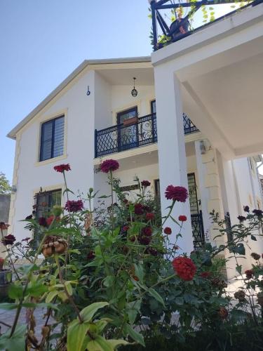 a white house with flowers in front of it at Ag ev in Mekhrably