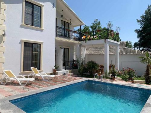 a house with a swimming pool in front of a house at Ag ev in Mekhrably