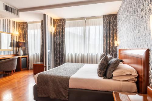 a hotel room with a bed and a desk at Hotel Palace Verona in Verona