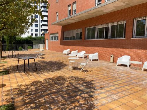a patio with chairs and tables and a brick building at Miresibilbao - Residencia Universitaria in Bilbao