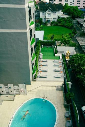 a person swimming in a swimming pool on a building at Oakwood Hotel & Residence Bangkok in Bangkok