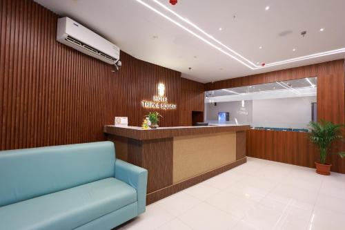 a waiting room with a blue chair and a counter at Hotel Tripka Square - walking distance from Baidyanath Dham Temple in Deoghar