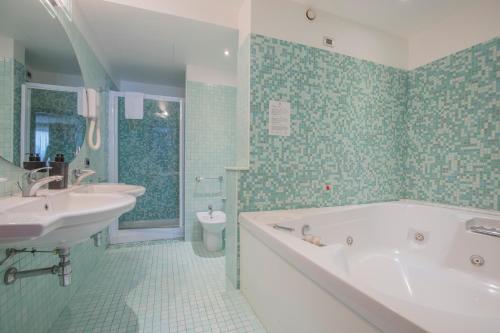 a bathroom with a tub and a sink and a toilet at Hotel Palace Verona in Verona