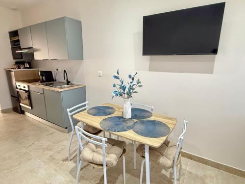 una sala da pranzo con tavolo e sedie e una cucina di La Villa Mar Y Sol - Bord de mer a Fos-sur-Mer