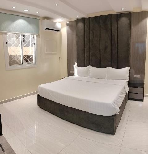 a bedroom with a large bed with white pillows at فلل الكناري in Taif