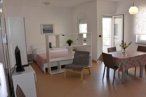 een slaapkamer met een bed en een tafel en een eetkamer bij Apartments Residence L'Ulivo in Rovinj