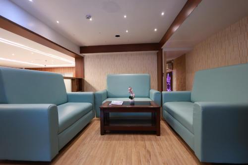 a waiting room with blue chairs and a table at Hotel Tripka Square - walking distance from Baidyanath Dham Temple in Deoghar