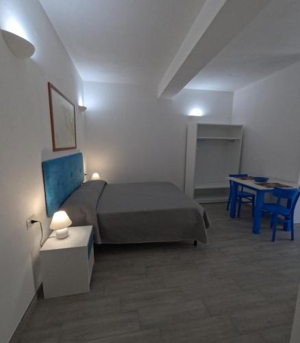 a bedroom with a bed and a table and a desk at B&b Ranieri in Le Castella