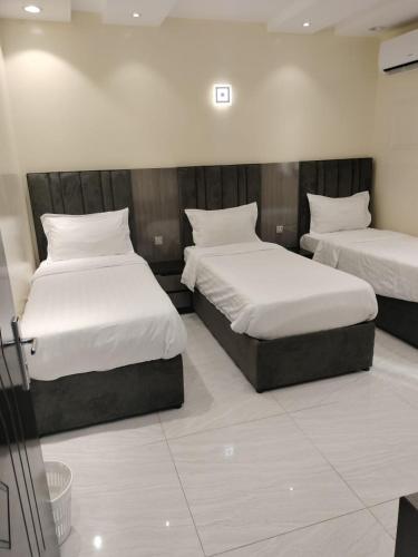 a room with two beds with white sheets at فلل الكناري in Taif