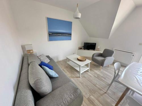 a living room with a gray couch and a table at Appartement 4 personnes à 100 m de la plage in Berck-sur-Mer