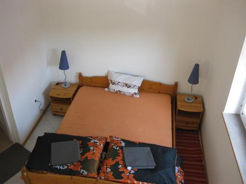 シオーフォクにあるCity Apartman Siófokのベッドルーム1室(ベッド1台、ナイトスタンド2台、ランプ2つ付)