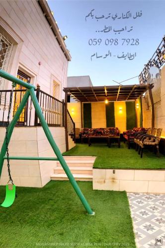 a playground with a green pole in the grass at فلل الكناري in Taif