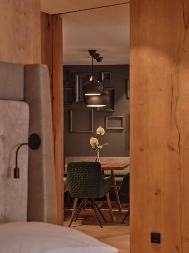 a bedroom with a table and a dining room at DAS EDELWEISS - Salzburg Mountain Resort in Grossarl