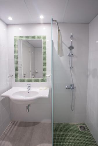 a bathroom with a sink and a shower with a mirror at Nicholas Color Hotel in Ayia Napa