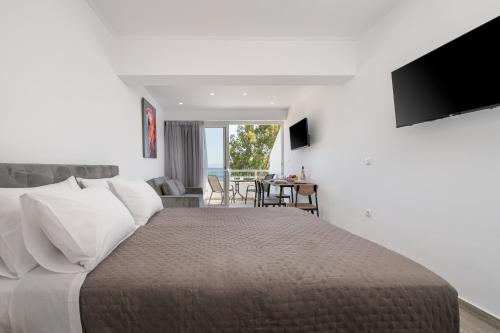 a bedroom with a large bed and a living room at Kos Mare - Elegant Beachfront Stay in Paradeísi