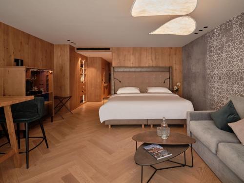 a hotel room with a bed and a couch at DAS EDELWEISS - Salzburg Mountain Resort in Grossarl