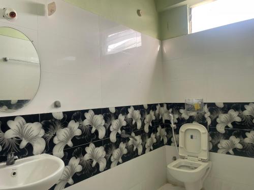 a bathroom with a sink and a toilet and a mirror at Elysium Inn in Hyderabad