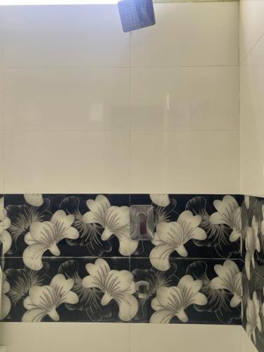 a tile wall with a bunch of flowers on it at Elysium Inn in Hyderabad