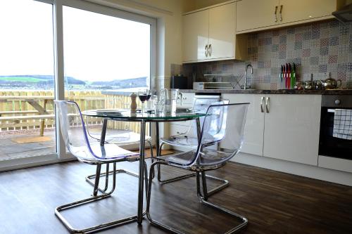 uma cozinha com uma mesa e duas cadeiras e uma janela em Otter Cottage em Inverness
