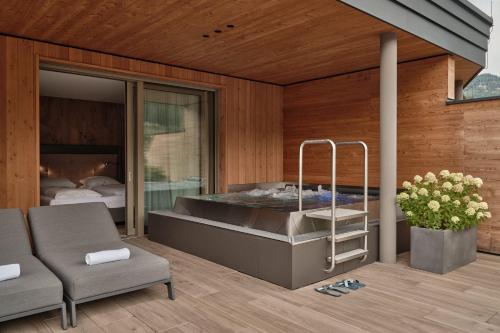 a bedroom with a large tub in a room at DAS EDELWEISS - Salzburg Mountain Resort in Grossarl