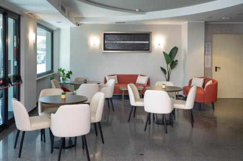 a dining room with tables and white chairs at Hotel Riviera in Porto San Giorgio