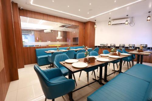a dining room with blue chairs and tables at Hotel Tripka Square - walking distance from Baidyanath Dham Temple in Deoghar