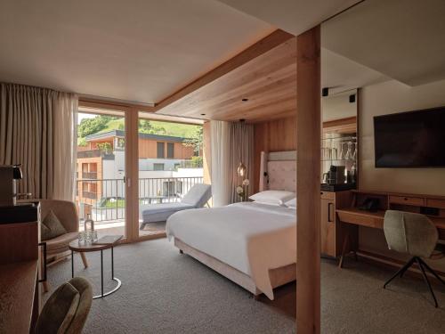a hotel room with a bed and a balcony at DAS EDELWEISS - Salzburg Mountain Resort in Grossarl