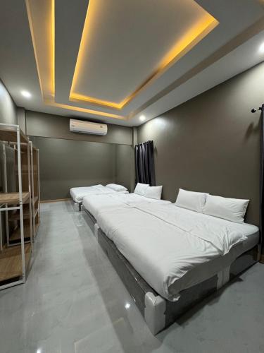 a room with a row of beds in a room at นงนุช วิลเลจ&พลูวิลล่า in Ban Nong Bua