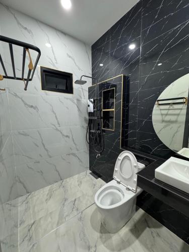 a bathroom with a toilet and a sink and a mirror at นงนุช วิลเลจ&พลูวิลล่า in Ban Nong Bua