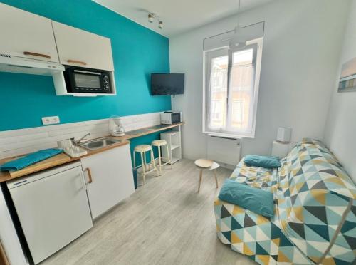 un salon avec un canapé et une cuisine dans l'établissement Studio BLEU - à 100 m de la plage de Berck, à Berck-sur-Mer