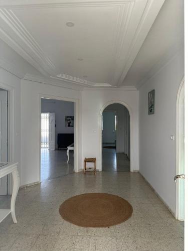 a white room with a table and a rug on the floor at Dar Aïcha 