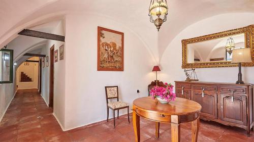 una sala da pranzo con un tavolo e uno specchio di El Membrillo casa rural ad Arcos de la Frontera