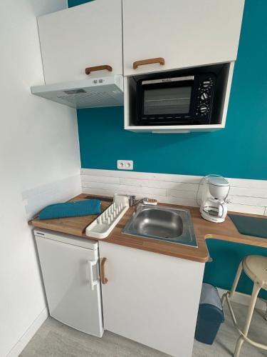 une petite cuisine avec un évier et un micro-ondes dans l'établissement Studio pour 2 personnes à 100m de la plage, à Berck-sur-Mer