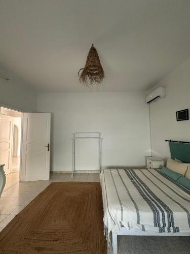 a bedroom with a bed and a white wall at Dar Aïcha 