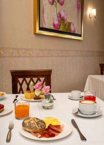 a table with plates of food and drinks on it at Hotel Riviera in Porto San Giorgio