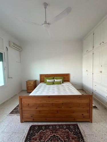 a bedroom with a wooden bed in a white room at Dar Aïcha 