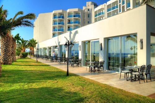 a building with tables and chairs in front of it at Le Bleu Hotel & Resort Kusadasi in Kusadası