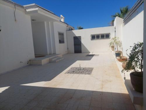 an empty courtyard of a white building with a door at Dar Aïcha 