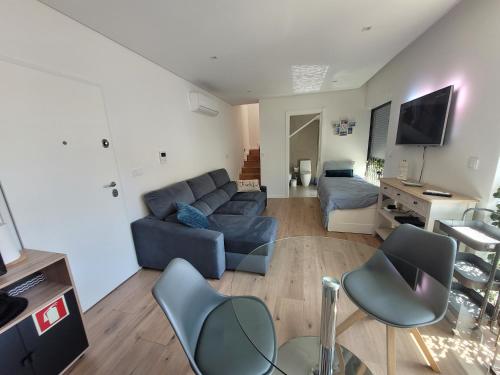 a living room with a blue couch and chairs at Moliceiro HOUSE in Aveiro
