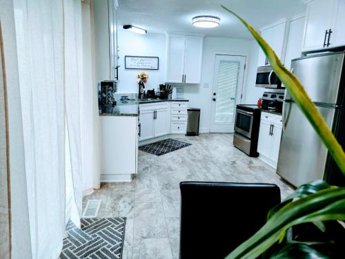 a kitchen with white cabinets and a black appliances at Cozy 4 bedroom home & Large Fenced Yard in Fayetteville