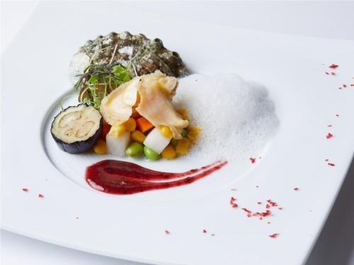un plato de comida con verduras en un plato blanco en お宿行灯鳥羽, en Toba