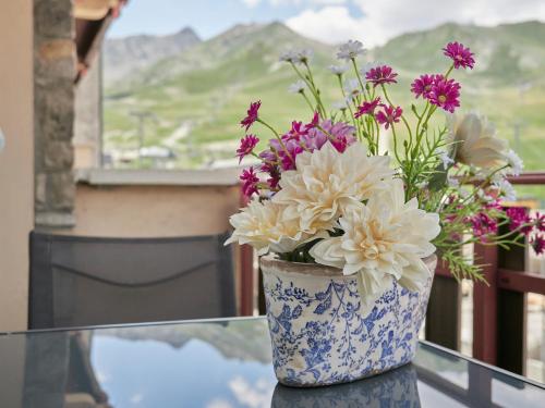 a vase filled with flowers sitting on a glass table at Envalira Vacances - Menta in Pas de la Casa