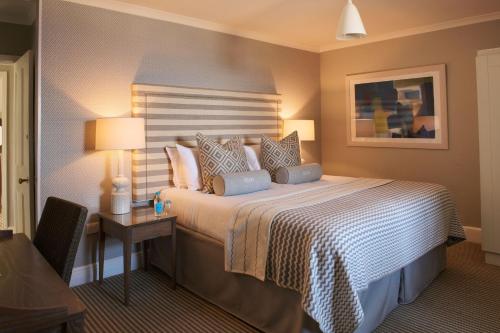 a bedroom with a bed and a table with a lamp at Harbour Hotel & Spa St Ives in St Ives