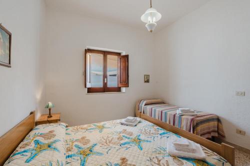 Un dormitorio con una cama y un espejo y una ventana. en Casa Damari-Fronte spiaggia, en Petrosino