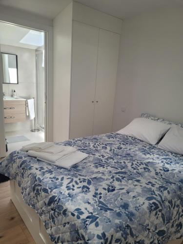 a bedroom with a bed with a blue and white blanket at Moliceiro HOUSE in Aveiro