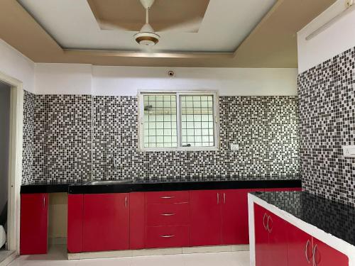 a kitchen with red cabinets and a window at Elysium Inn in Hyderabad