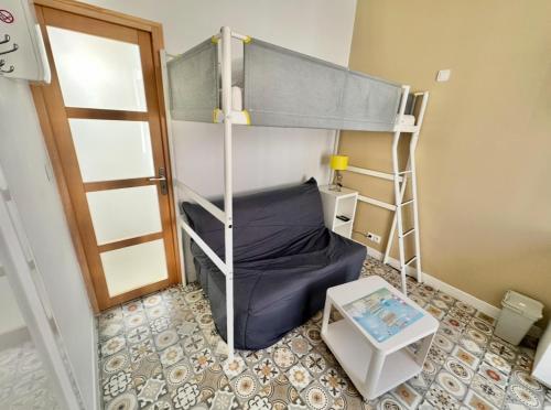 Cette petite chambre comprend des lits superposés et une table. dans l'établissement Studio 3 personnes à 100m de la mer, à Berck-sur-Mer