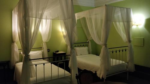 a bedroom with two beds with white drapes at Casa Da Avo - Turismo De Habitacao in Torre de Moncorvo