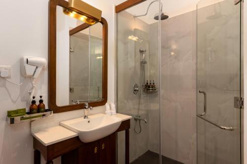 a bathroom with a sink and a shower at Hotel Suisse Kandy - Since 1890 in Kandy