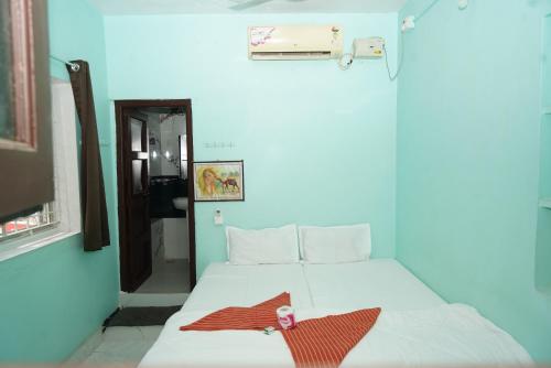 a bedroom with a bed with a towel on it at Ranjana Guesthouse in Hampi